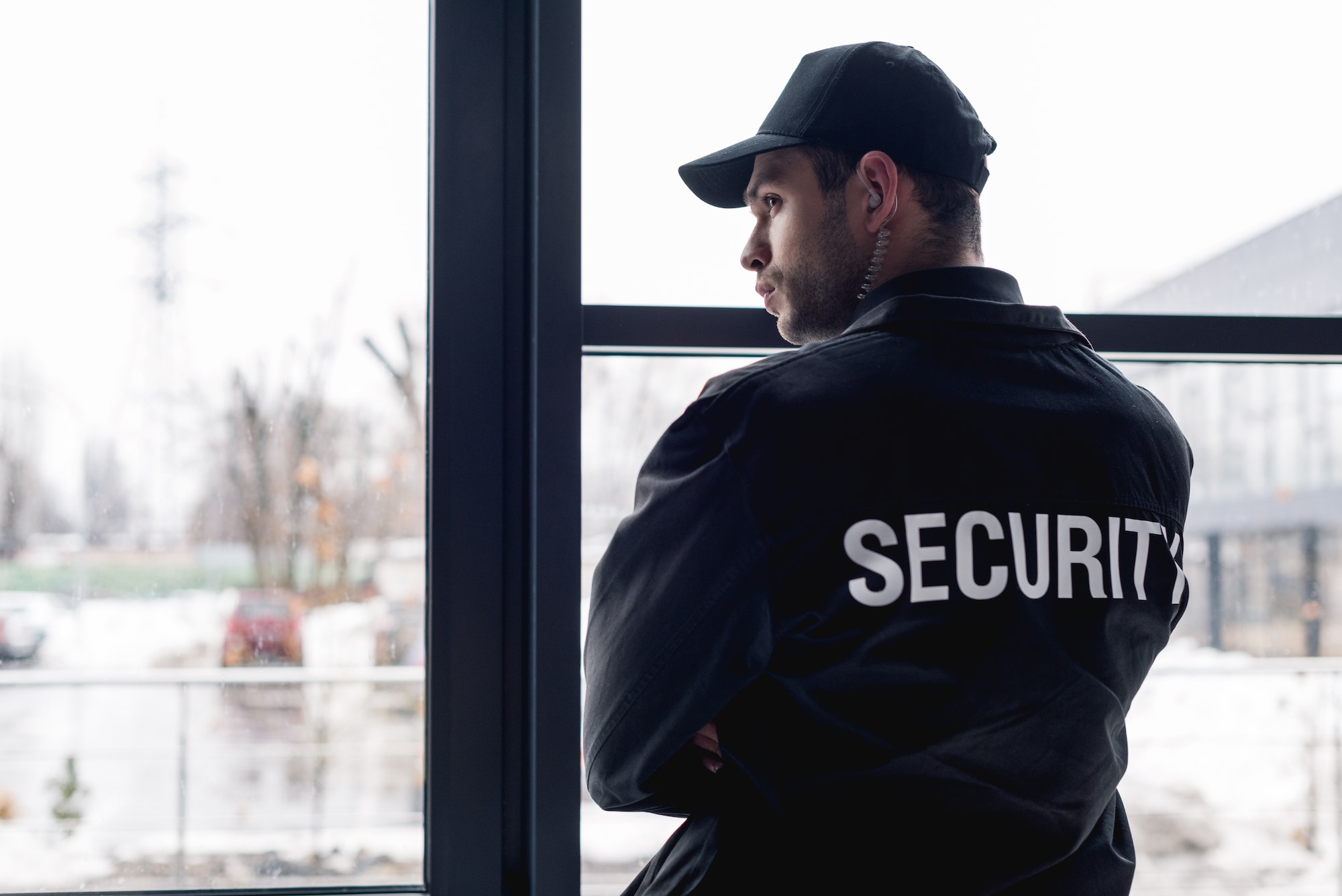 Rear view of guard in black uniform with earphone - Vadium Security